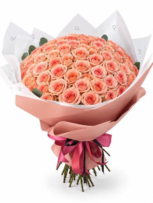 Bouquet da QRoses com 100 rosas em tons de pêssego, damasco, blush e creme, envolvido em papel rosa e branco com fita da marca.
