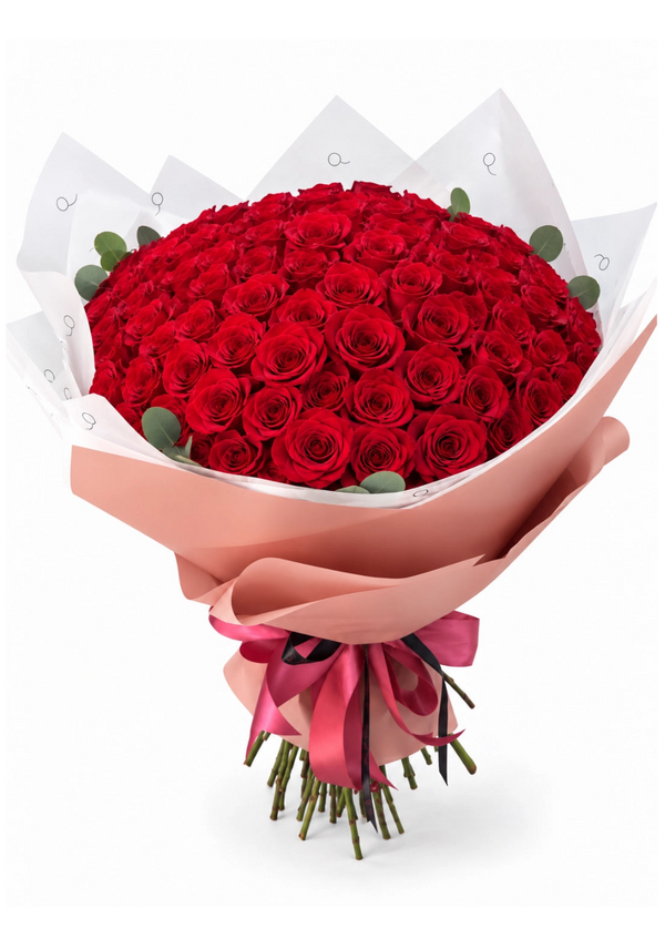 Bouquet da QRoses com 100 rosas vermelhas, envolvido em papel rosa e branco com fita da marca.