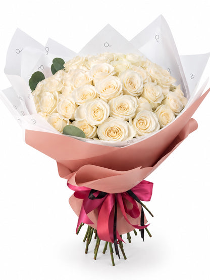 Bouquet da QRoses com 50 rosas brancas em tons marfim e creme, envolvido em papel rosa e branco com fita da marca.