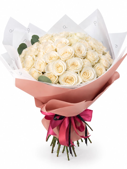 Bouquet da QRoses com 50 rosas brancas em tons marfim e creme, envolvido em papel rosa e branco com fita da marca.