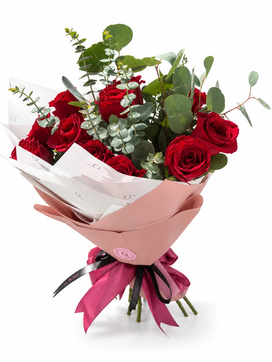 Bouquet Premium da QRoses com rosas vermelhas e eucalipto, envolvido em papel rosa e branco com fita da marca.