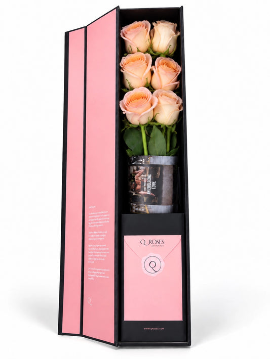 Flute Box da QRoses com rosas em tons de pêssego, damasco e blush, cartão e envelope da marca, apresentada em fundo branco.