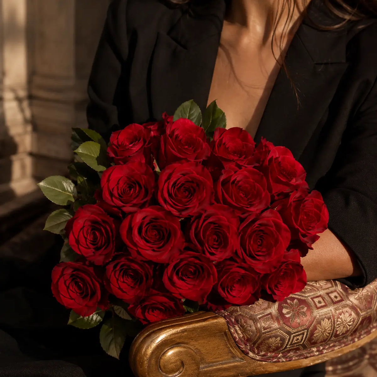 Close-up de bouquet de rosas vermelhas premium QRoses, com pétalas intensas e folhagem verde, num ambiente elegante e sofisticado.