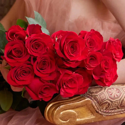 Buquê de rosas vermelhas em caixa de luxo - modelo sentada numa cadeira dourada| QRoses 