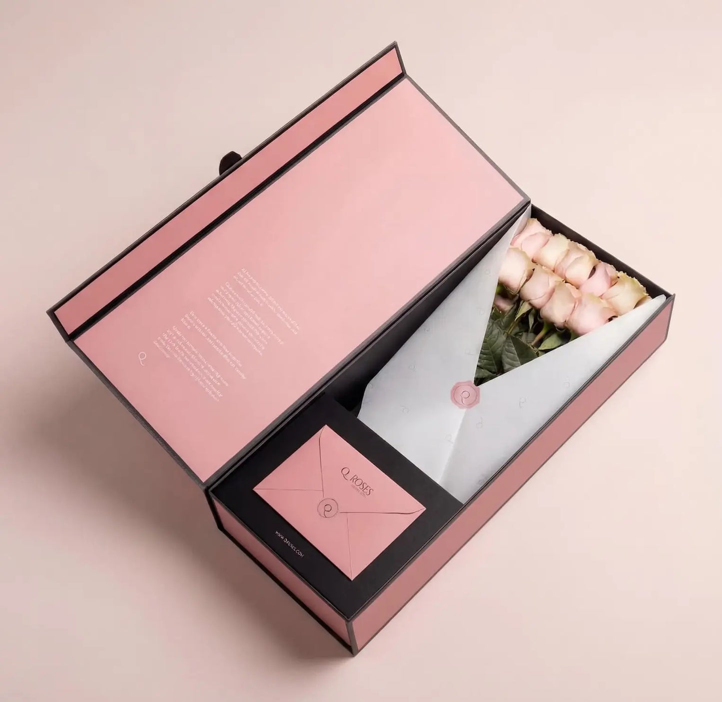 Caixa Signature Box QRoses com rosas cor-de-rosa premium, cartão QR e envelope elegante, apresentada numa embalagem rosa de luxo.