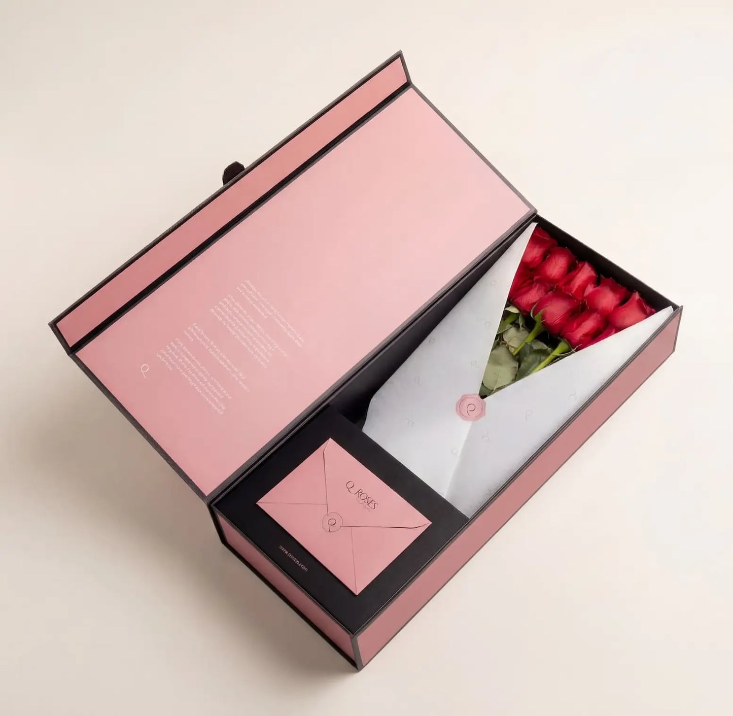 Caixa Signature Box QRoses com rosas vermelhas premium, cartão QR e envelope elegante, apresentada numa embalagem rosa de luxo.