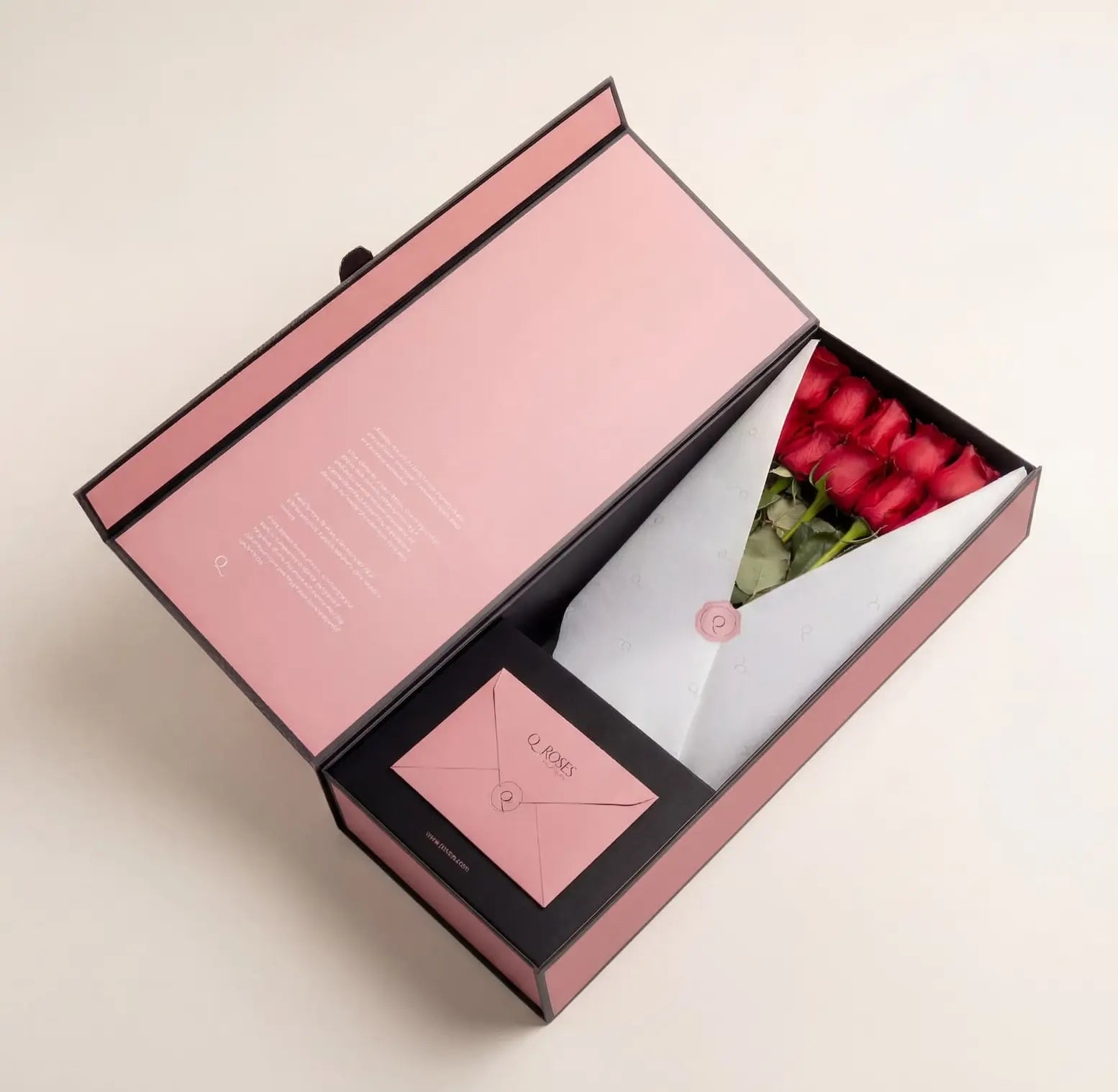 Caixa Signature Box QRoses com rosas vermelhas premium, cartão QR e envelope elegante, apresentada numa embalagem rosa de luxo.