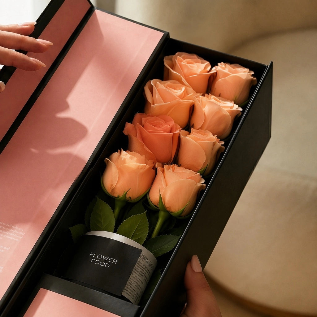 Close-up of the QROSES FLUTE gift box with eight premium peach roses, premium flower food container, and elegant blush pink interior packaging.