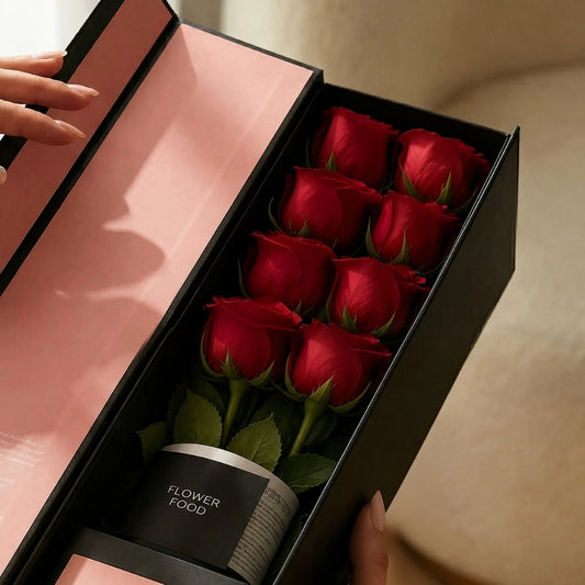 Close-up of the QROSES FLUTE gift box with eight premium red roses, premium flower food container, and elegant blush pink interior packaging.
