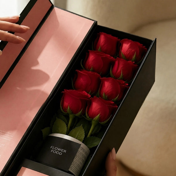 Close-up of the QROSES FLUTE gift box with eight premium red roses, premium flower food container, and elegant blush pink interior packaging.