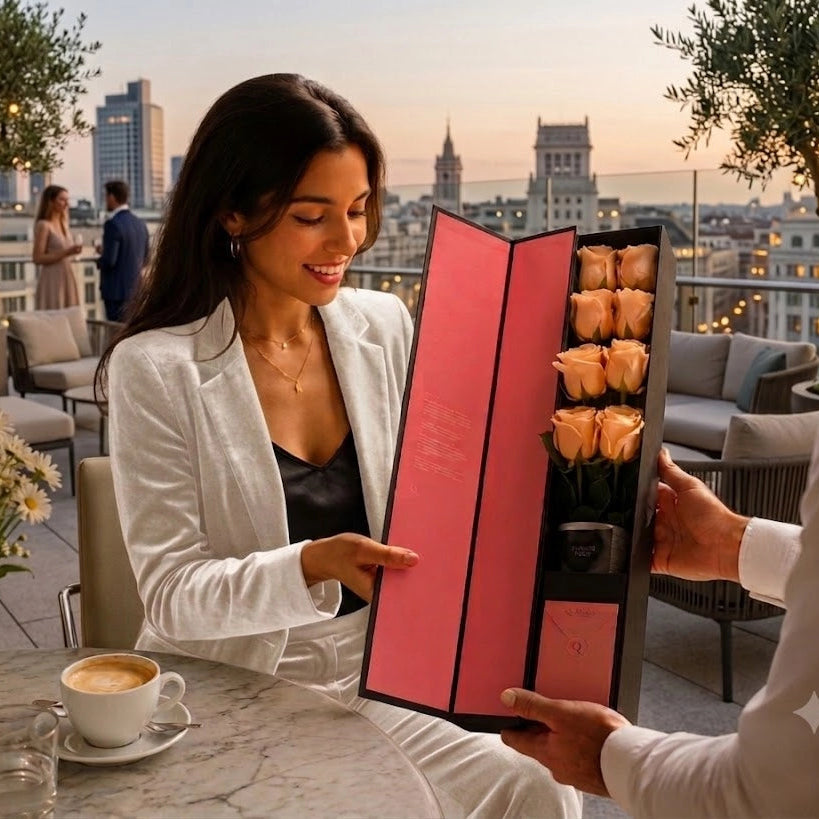 Elegant woman receiving a QROSES FLUTE gift box with eight premium peach roses inside a luxury hotel restaurant, highlighting an exclusive floral gifting experience with authentic emotion and sophisticated style.