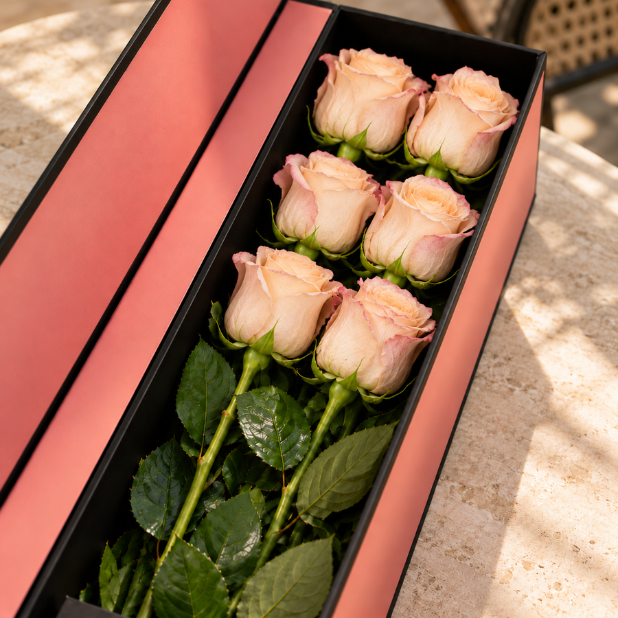 Caixa Flute com rosas cor-de-pêssego sobre uma mesa