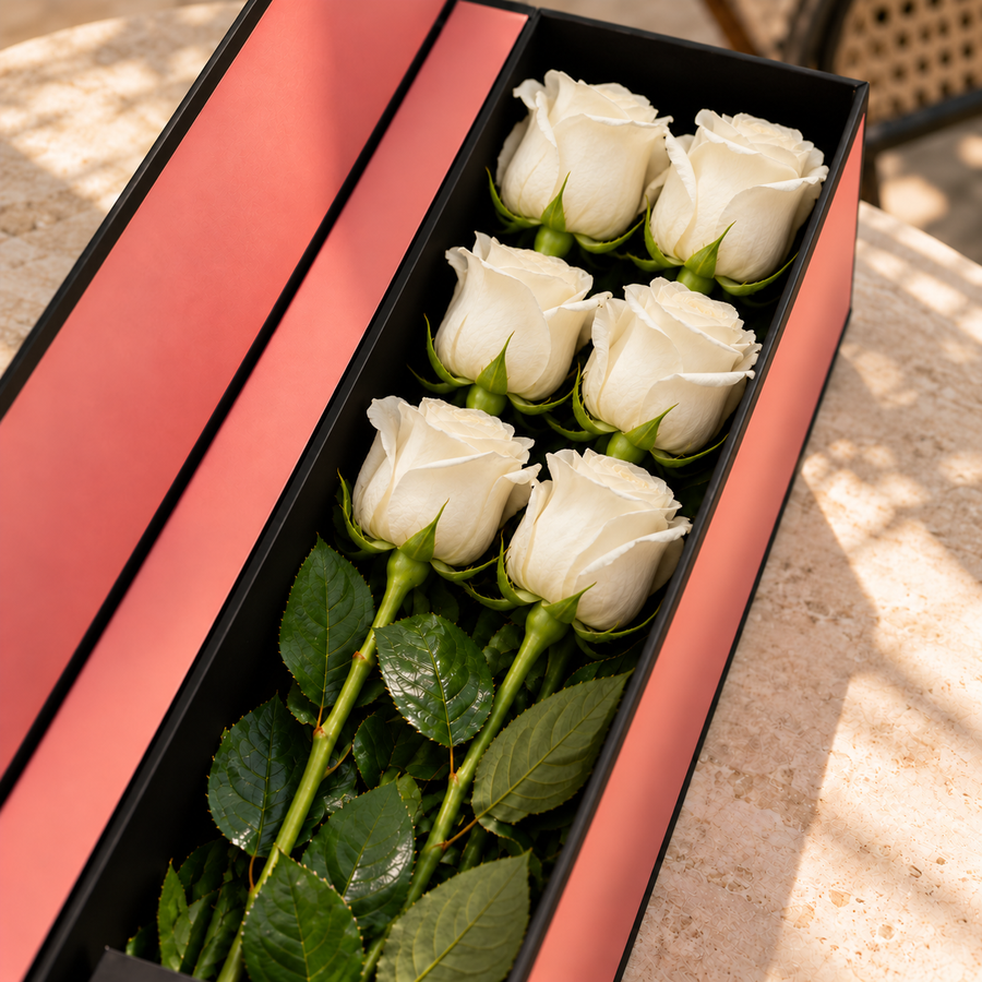 Caixa Flute de rosas brancas naturais sobre uma mesa de pedra