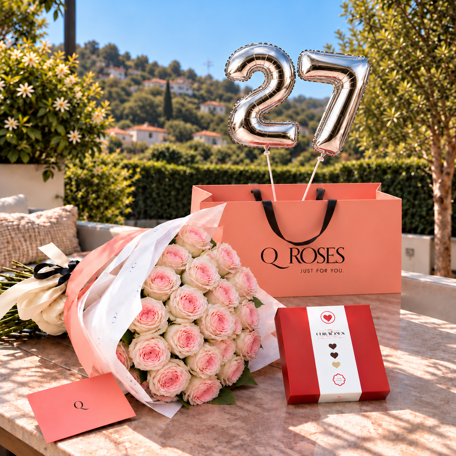 Edição de Aniversário QRoses — rosas pink-fruttetto, balões 27, laço creme e preto e envelope com monograma Q