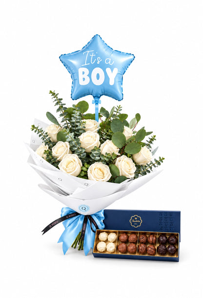 Bouquet QRoses de rosas brancas e eucalipto, com laço azul, balão “It's a Boy” e caixa aberta de chocolates, sobre fundo branco.