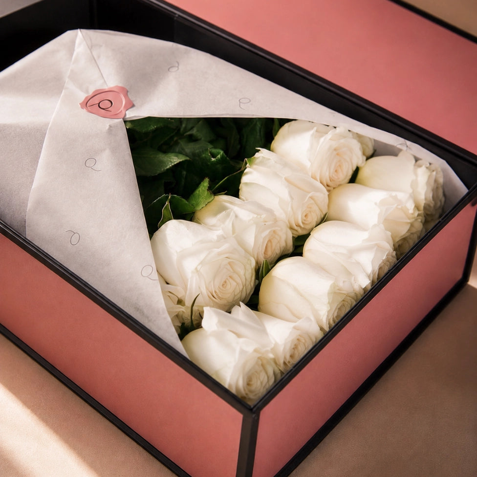 QROSES Signature Box with premium white roses arranged in two elegant rows inside a luxury pink gift box with white wrapping paper and premium presentation.