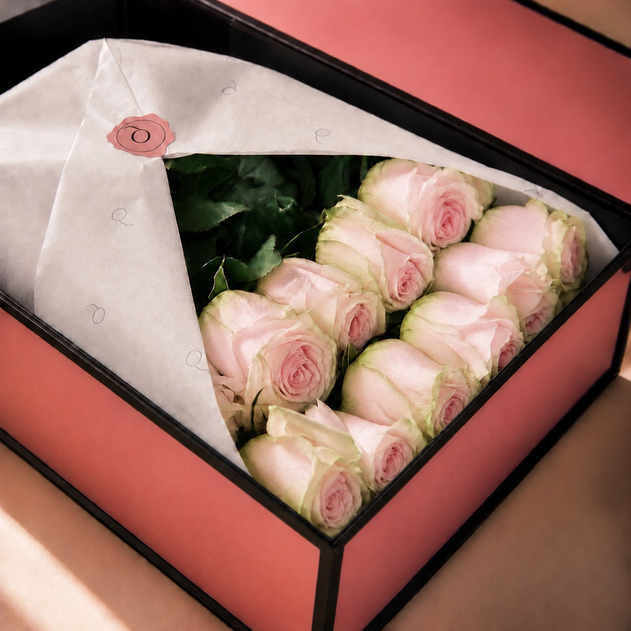 Caixa Signature com rosas cor-de-rosa pálido com bordos esverdeados e etiqueta QRoses