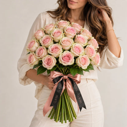 Modelo segurando Ramo Elegance de 25 rosas cor-de-rosa com bordas esverdeadas, mostrando a dimensão real do bouquet