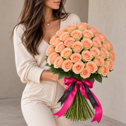 Mulher com Ramo Elegance 50 de rosas pêssego mostrando as dimensões do ramo