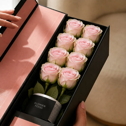 Open box of flute pink roses containing eight